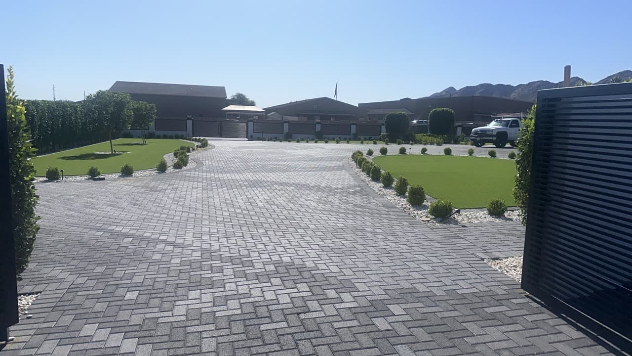 Completed paver driveway with herringbone pattern and landscaping in Mesa, AZ