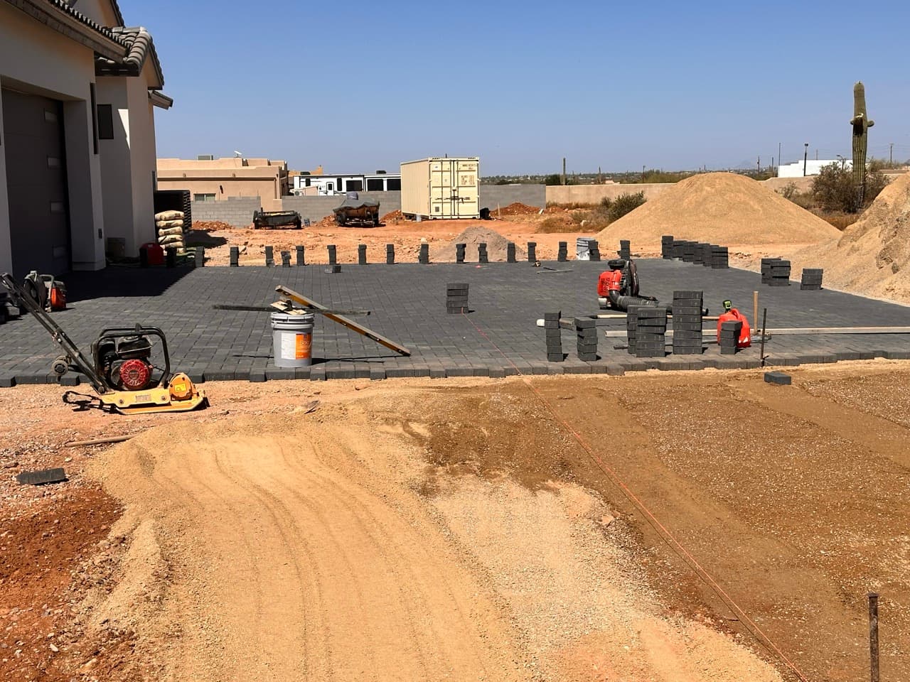 Crew laying interlocking pavers on compacted base in Mesa, AZ