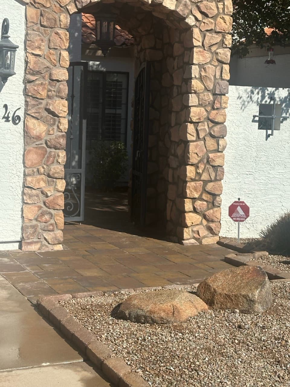 Travertine walkway leading to front entrance with stone archway in Mesa, AZ